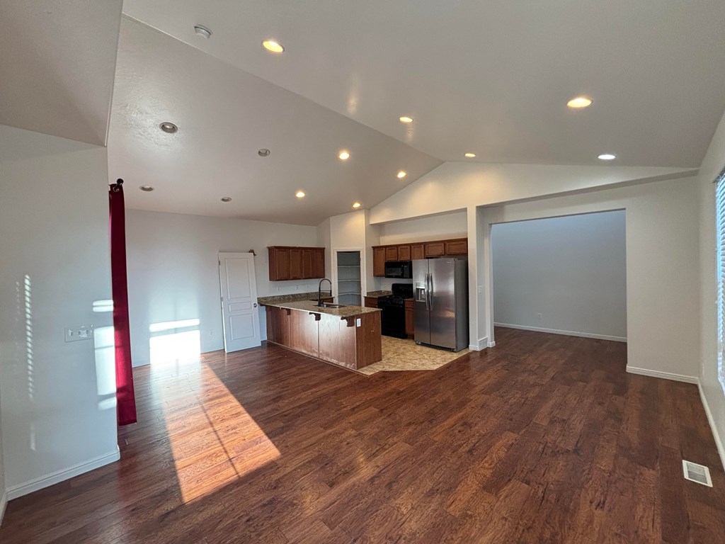 A kitchen with wooden floors and a refrigerator.