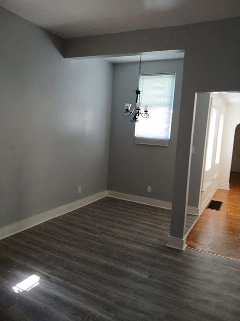 a empty living room with gray walls and wood floors