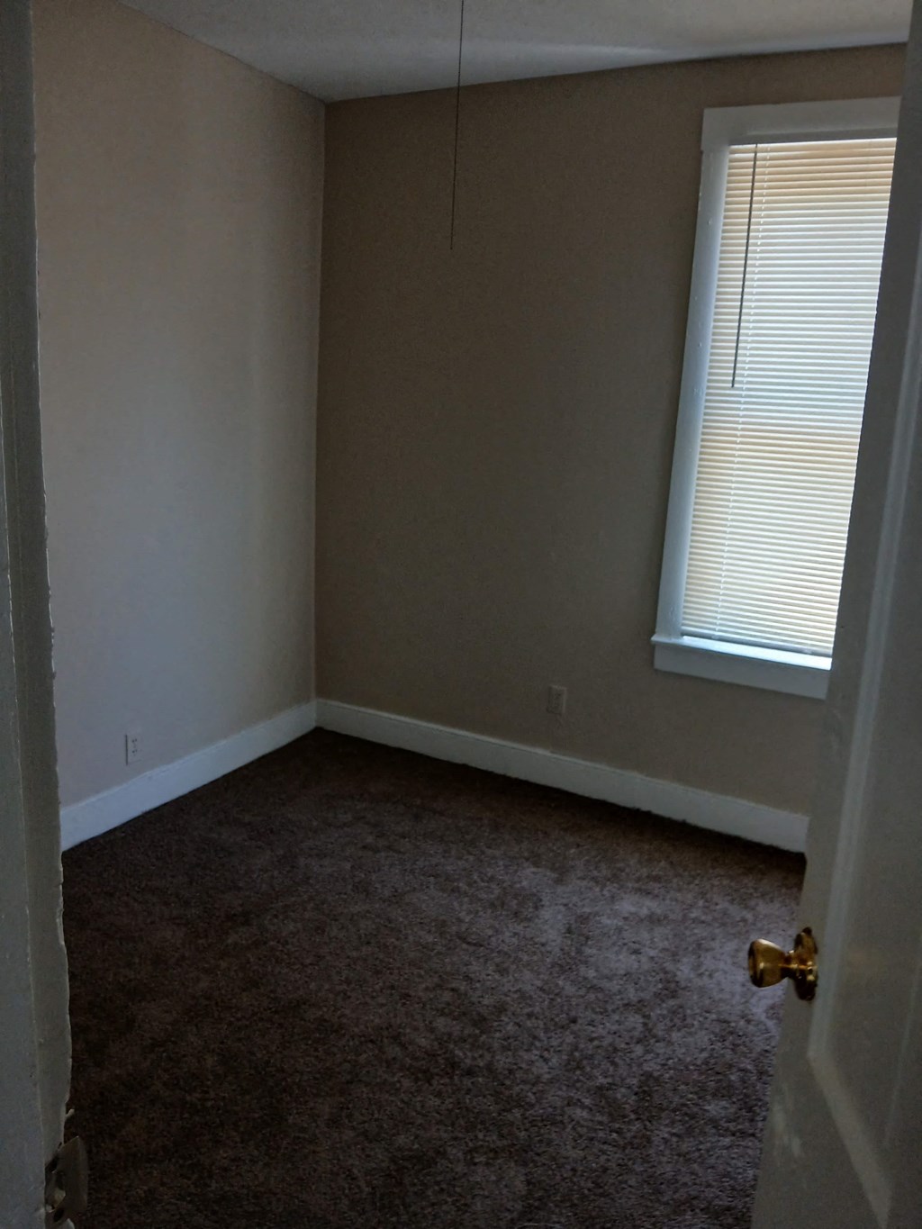 a room with a carpeted floor and a window