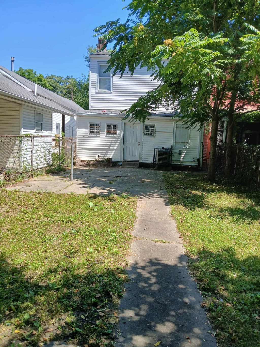 an empty sidewalk in front of a white house
