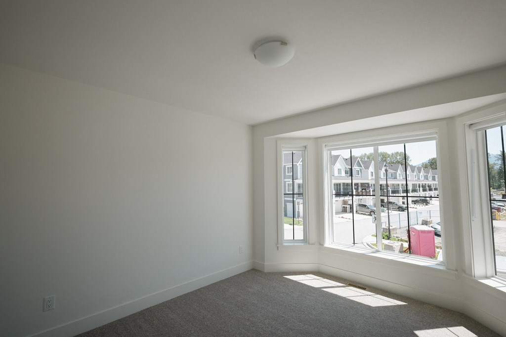 a living room with a large window and a carpet