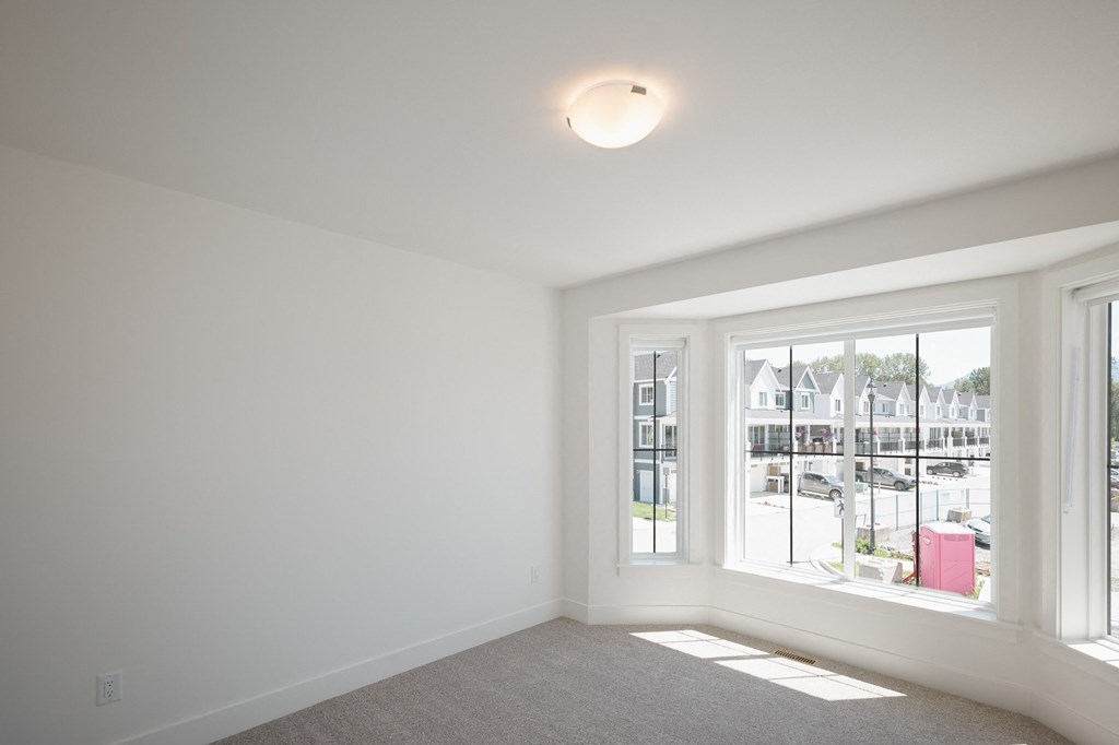 a living room with a large window and a carpet