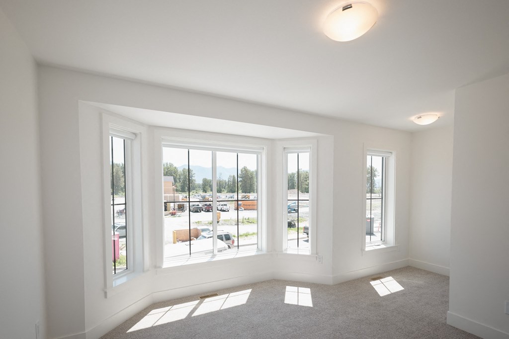 a living room with large windows and a carpet