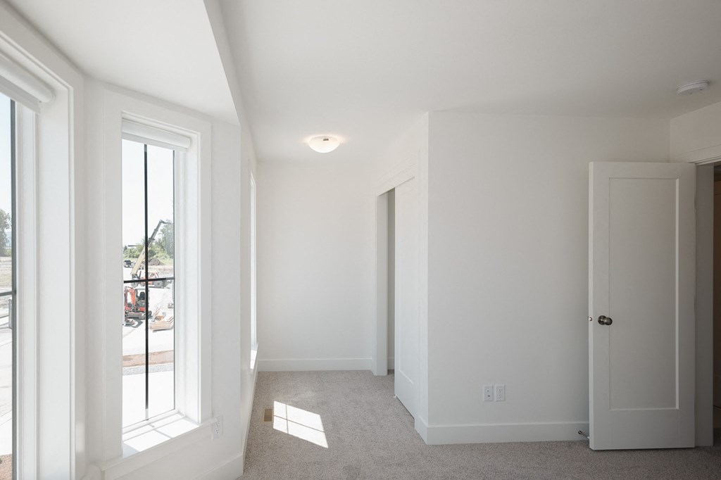 a living room with white walls and a large window