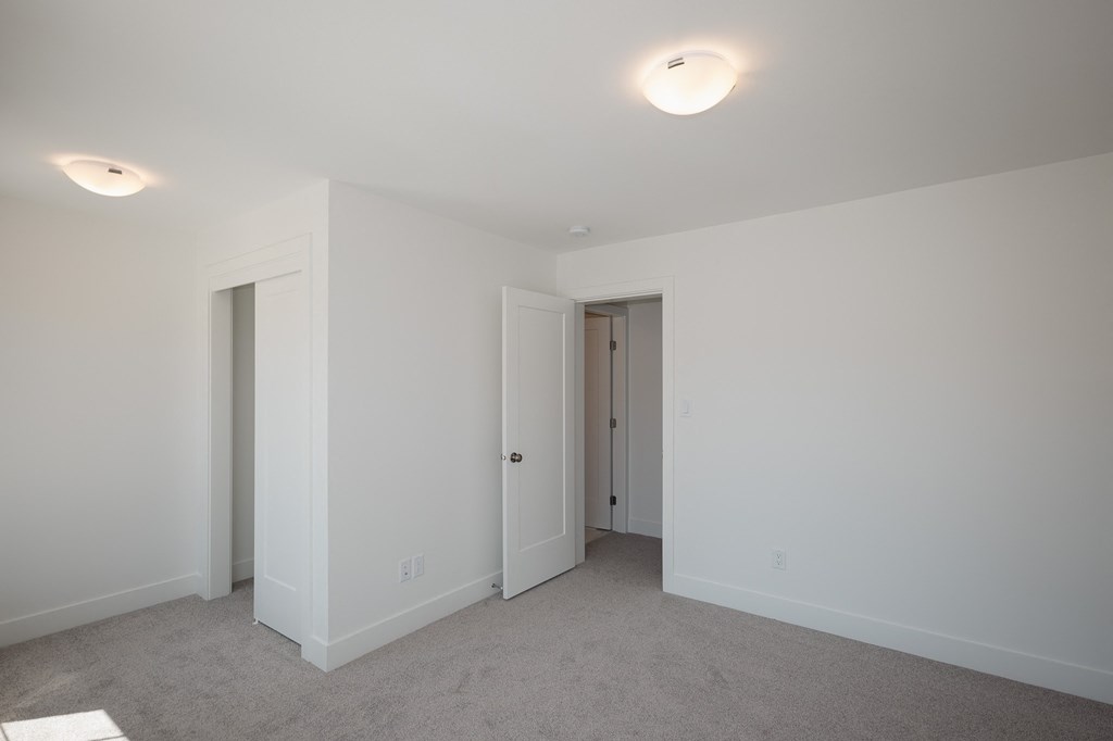 a bedroom with white walls and white doors and a carpeted floor