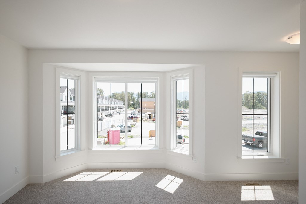 a living room with large windows and a carpeted floor