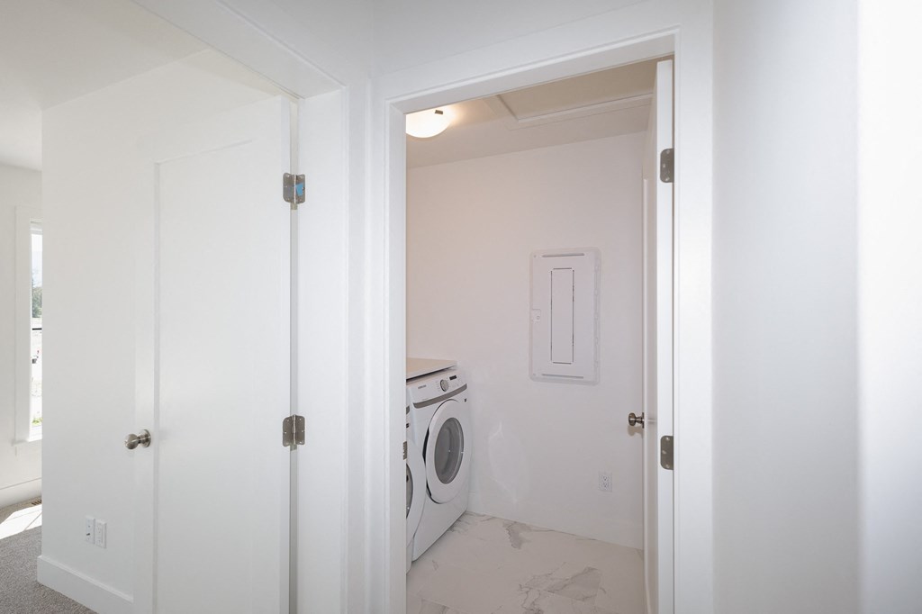 an empty laundry room with a washer and dryer in it