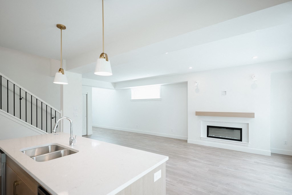 a white kitchen with a sink and a fireplace