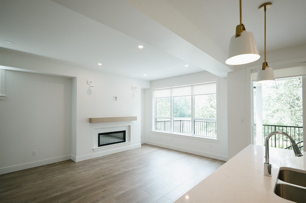a kitchen and living room with white walls and a fireplace