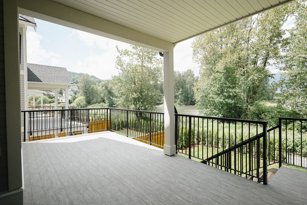 a porch with a view of a lake and a house