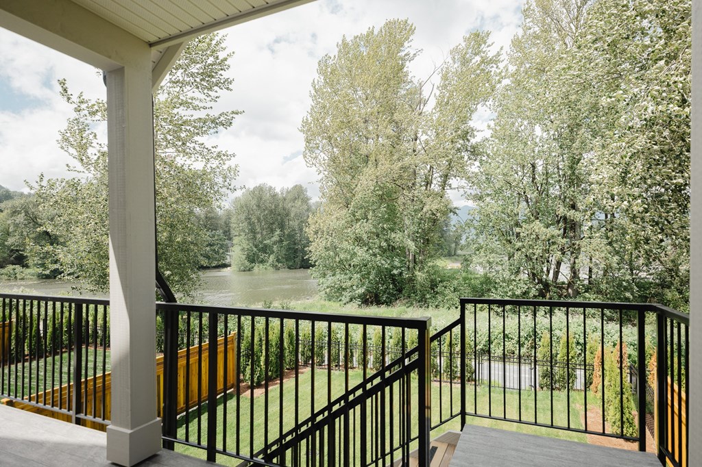 a porch with a view of a river and trees