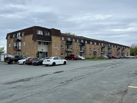 A parking lot with cars and a building in the background.