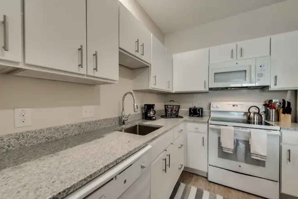 a kitchen with white cabinets and a counter top and a sink