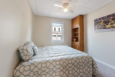 a bedroom with a bed and a ceiling fan
