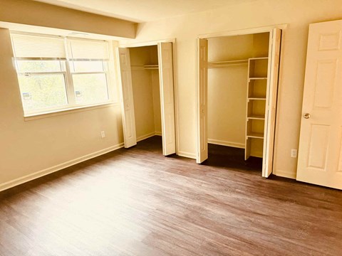 A room with a window, a door, and a closet.