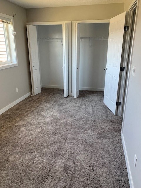 a room with a carpeted floor and two closet doors