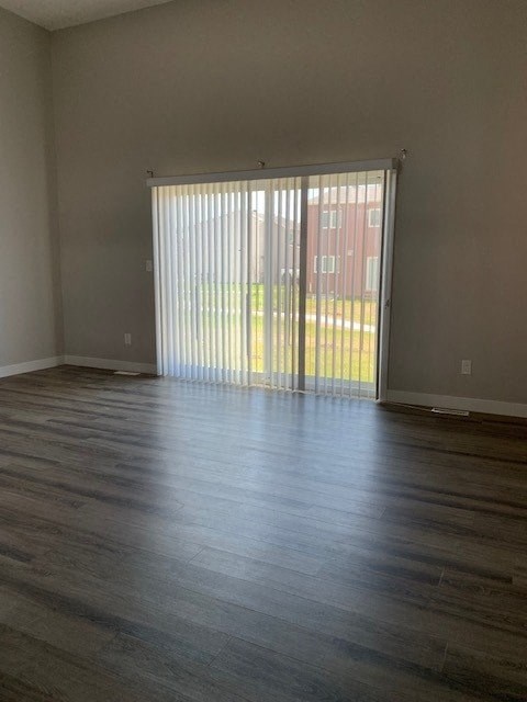 an empty living room with wood floors and a sliding glass door