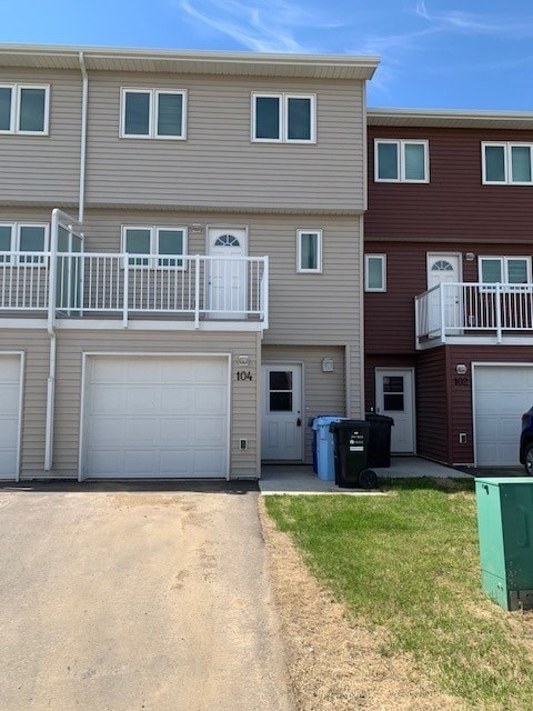 a house with two garage doors and a balcony