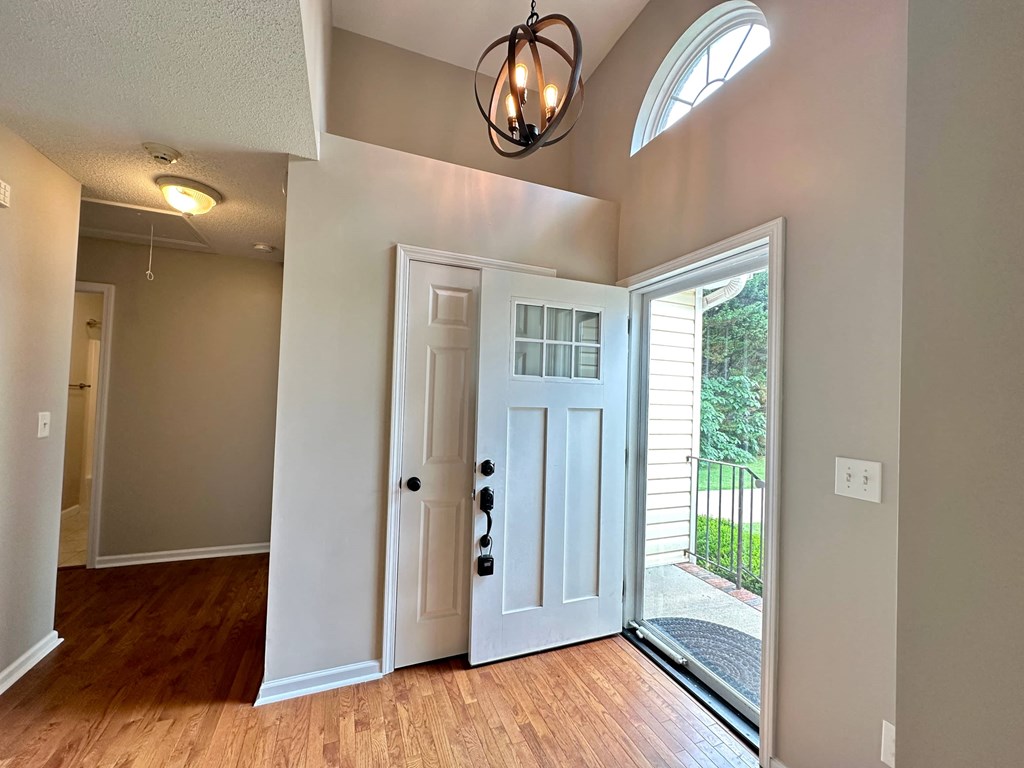an empty living room with a white door and a window