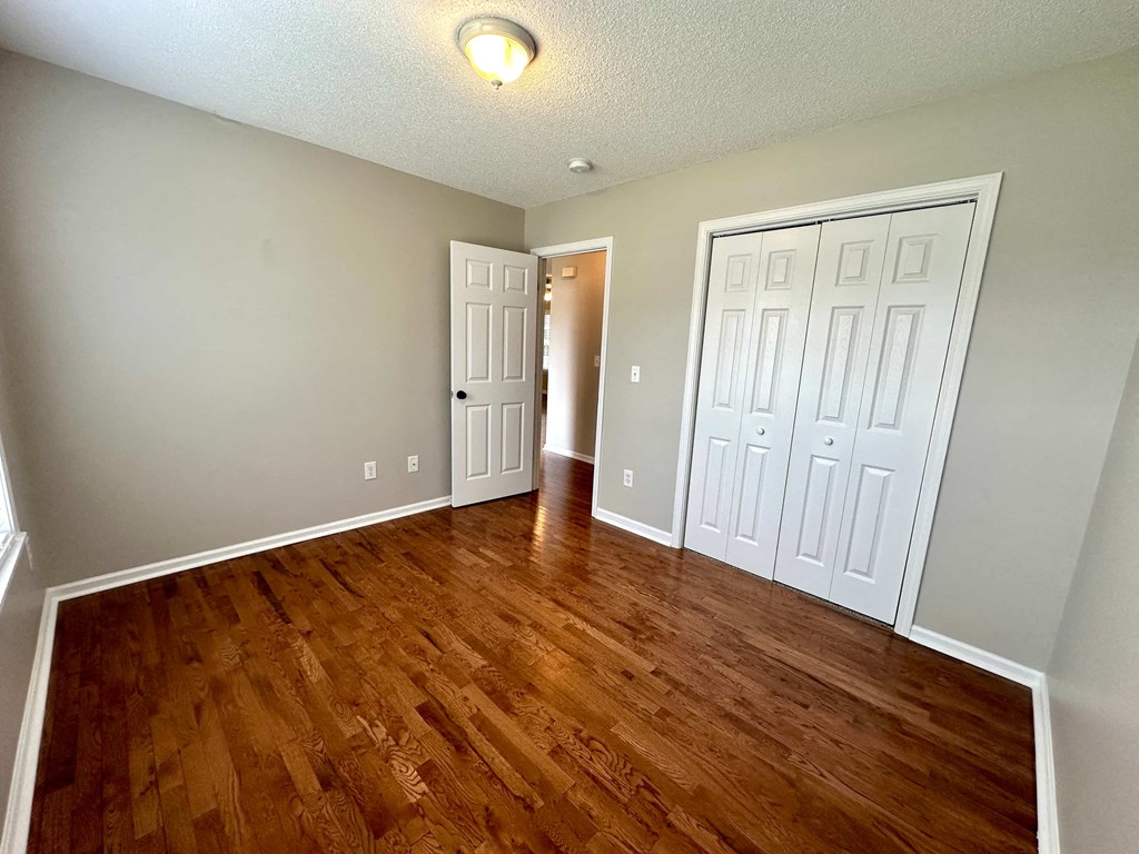 a living room with a hard wood floor and two closets
