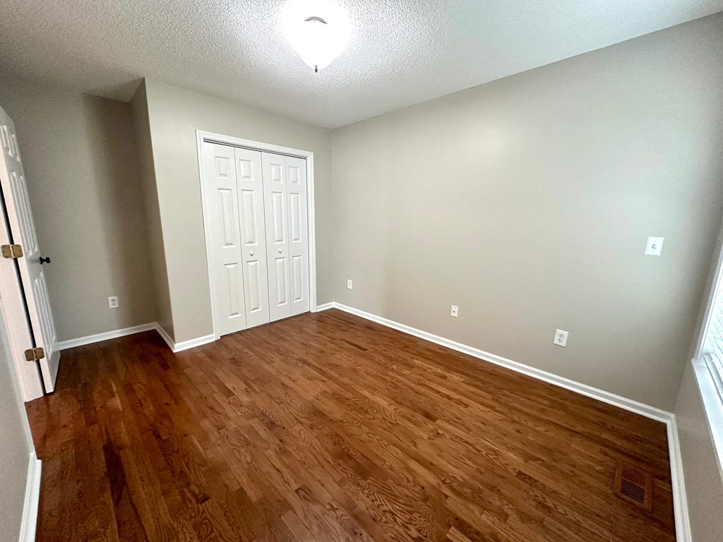 a living room with wood flooring and a white door