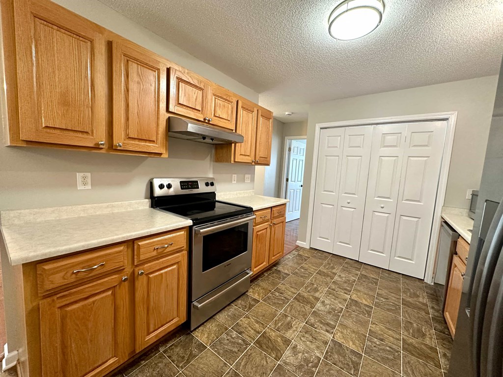 a kitchen with wooden cabinets and stainless steel appliances