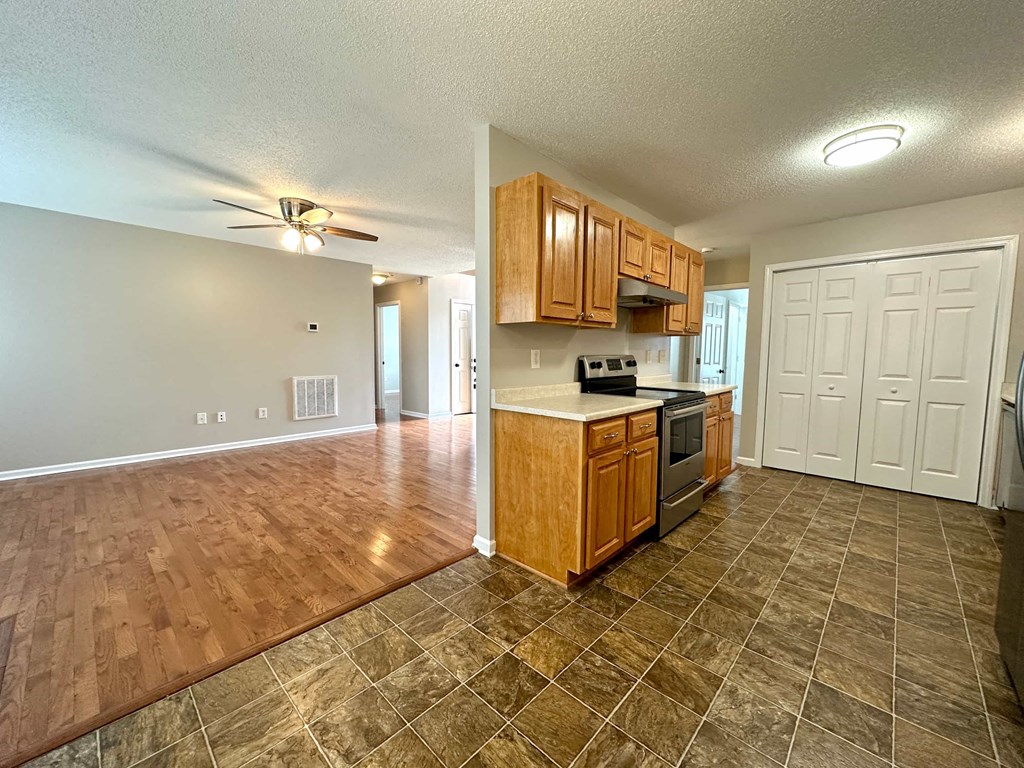 an empty kitchen and living room with wood floors
