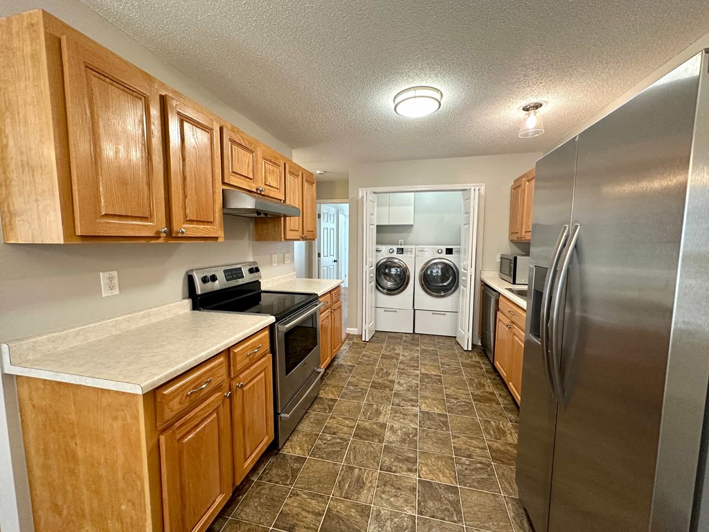 a kitchen with stainless steel appliances and wooden cabinets