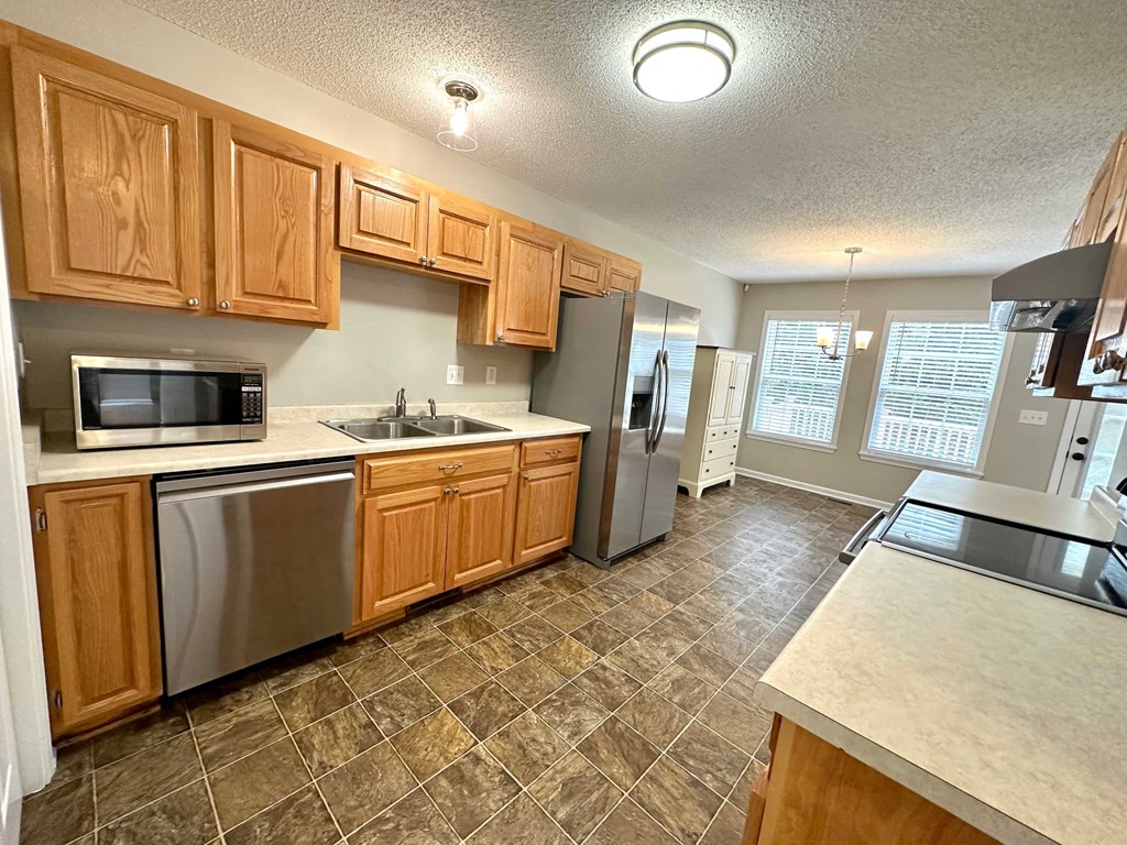 a kitchen with stainless steel appliances and wooden cabinets