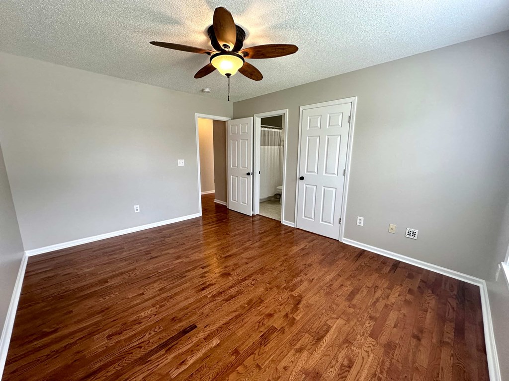 a living room with wood floors and a ceiling fan