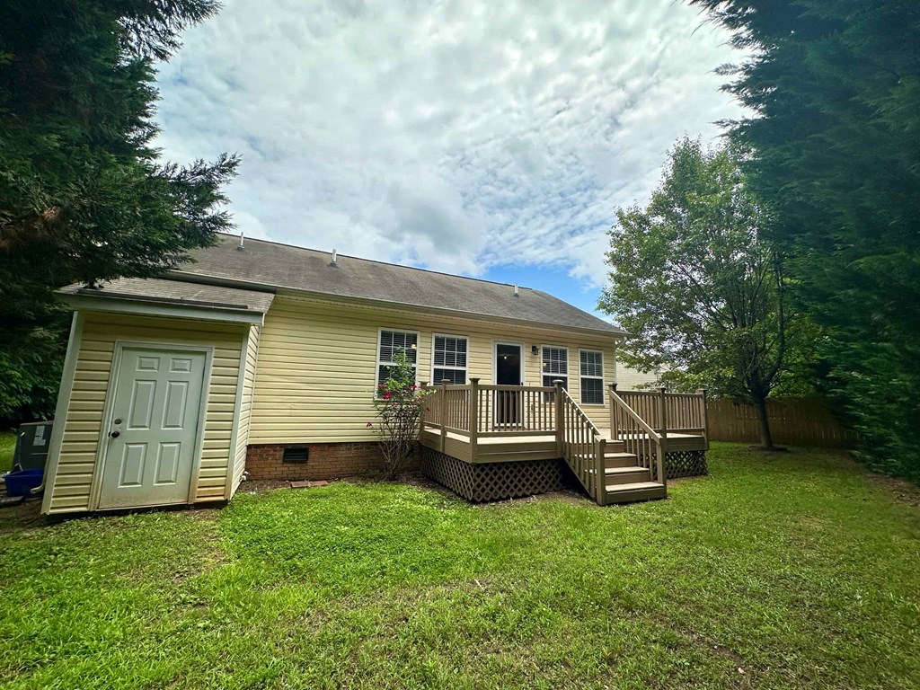 a yellow house with a deck and a white door