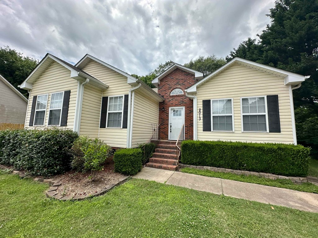 a yellow house with a sidewalk in front of it