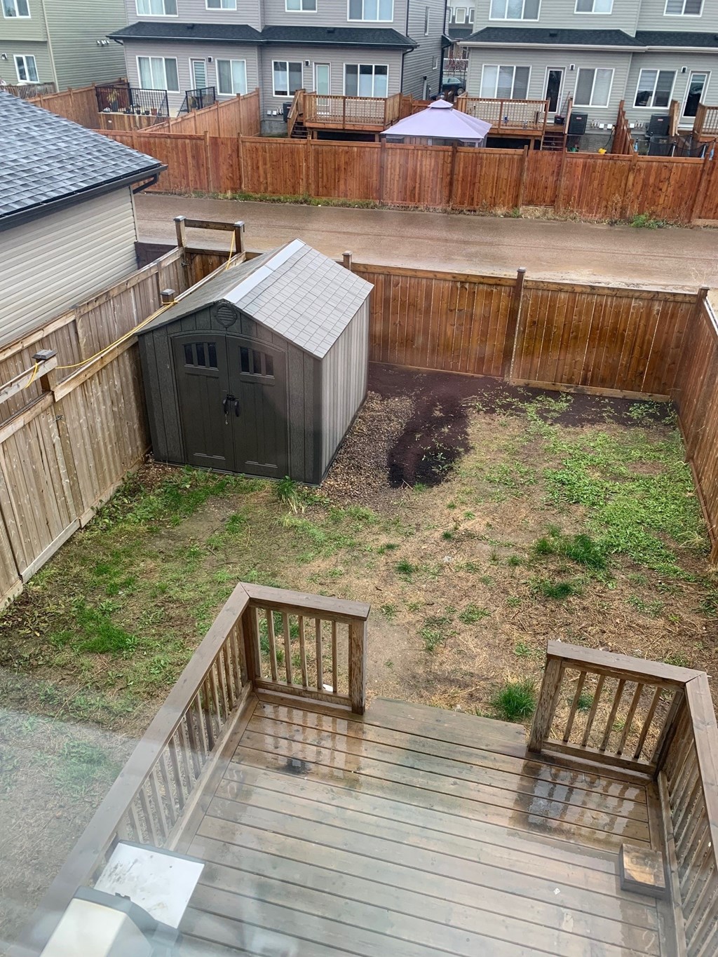a small backyard with a shed and a deck