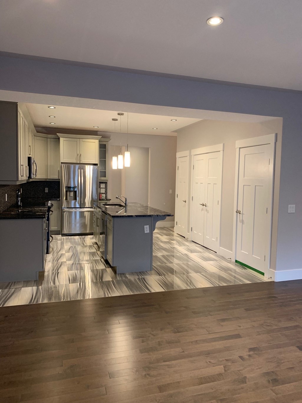 an open kitchen and living room with a hardwood floor