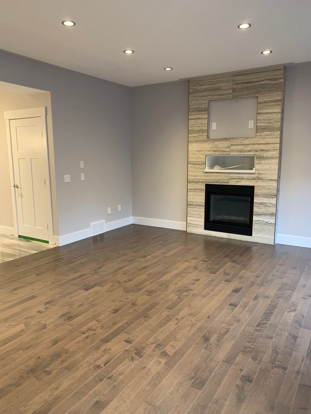 a living room with a fireplace and wooden floors