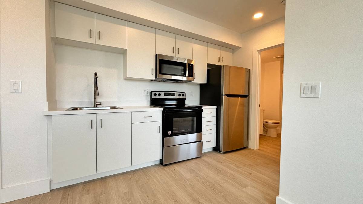 A kitchen with white cabinets and stainless steel appliances.