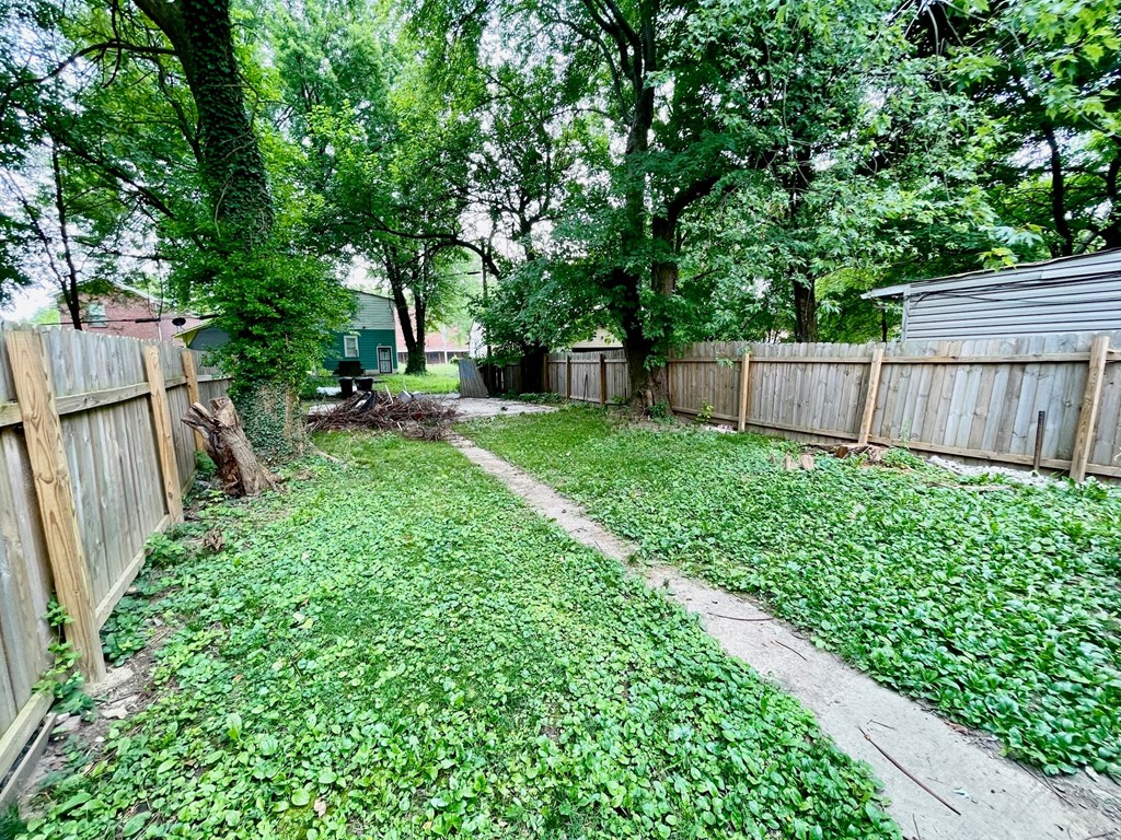 the backyard of a house with a wooden fence