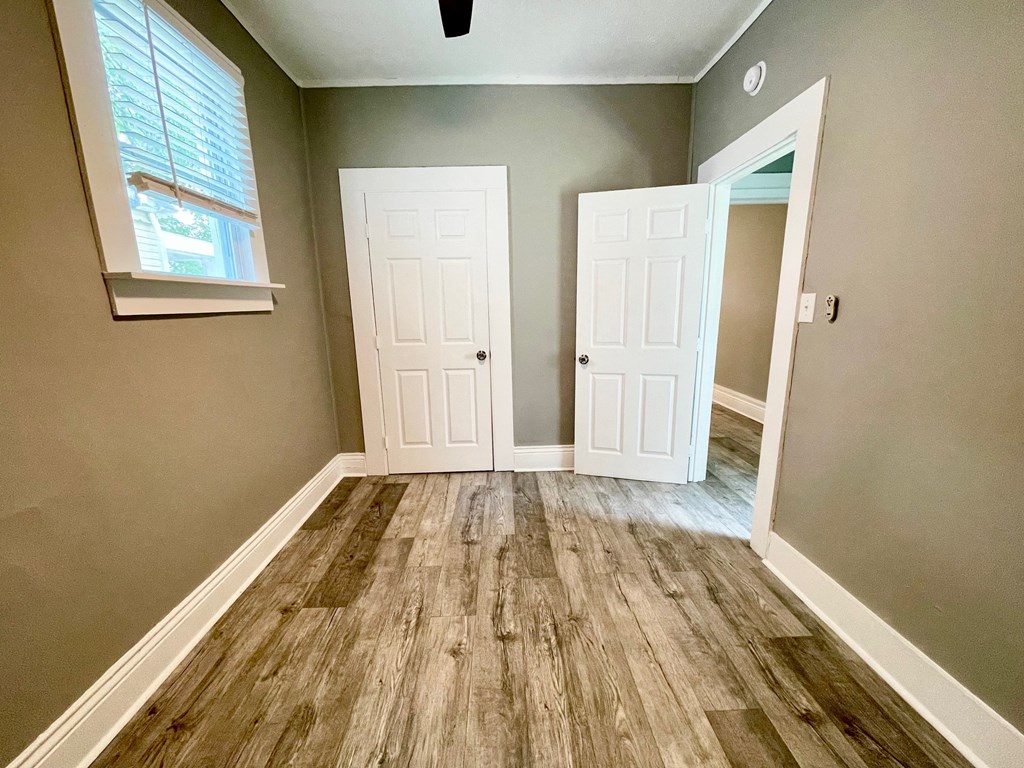 an empty room with wooden floors and white doors