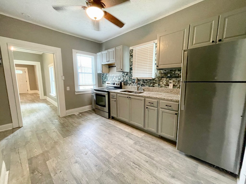 an empty kitchen with stainless steel appliances and white cabinets