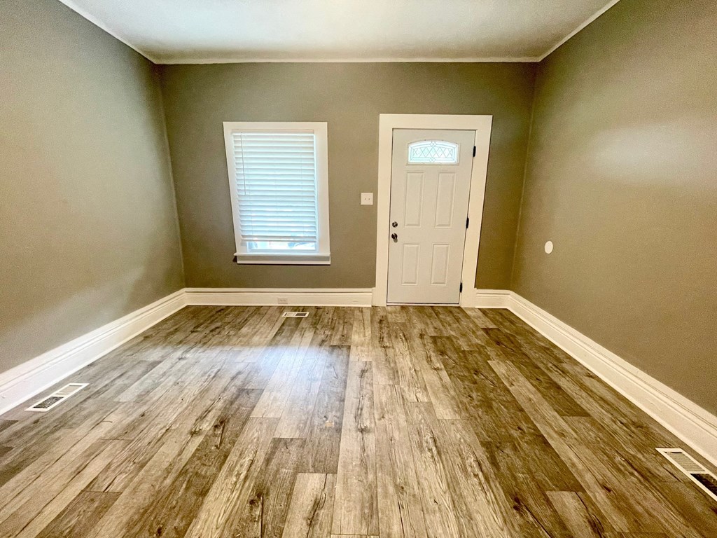 an empty room with wooden floors and a white door