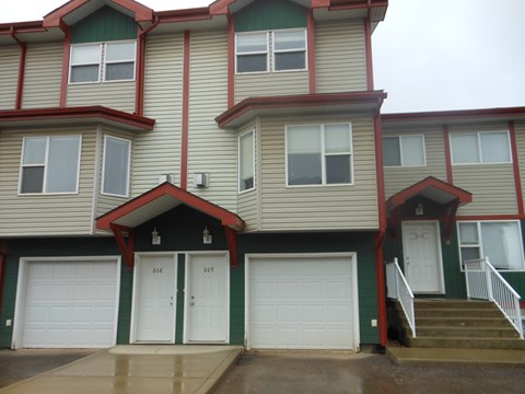 the front of a house with white garage doors