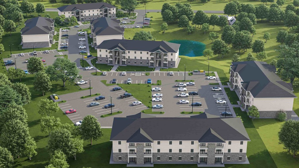 an aerial view of a parking lot with a large building and other buildings and cars