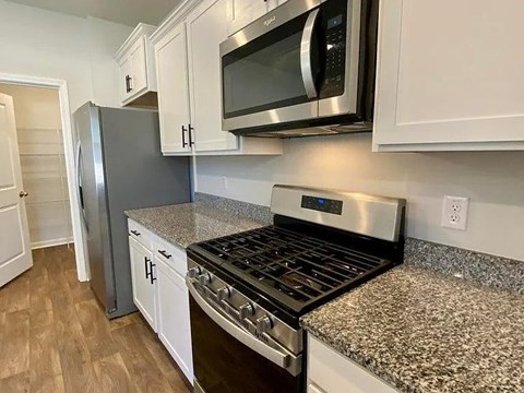A kitchen with a stove top oven and microwave above it.