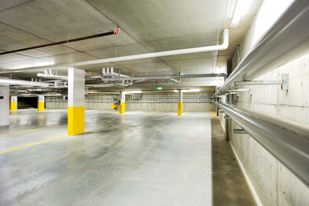 a empty parking garage with yellow and white pillars