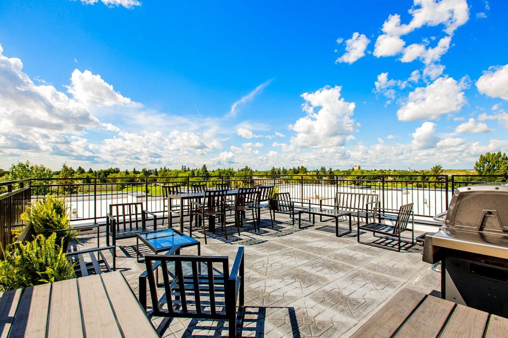 a patio with tables and chairs and a view of a lake