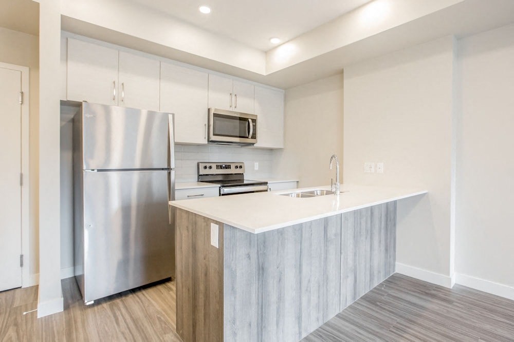 a modern kitchen with stainless steel appliances and a white counter top
