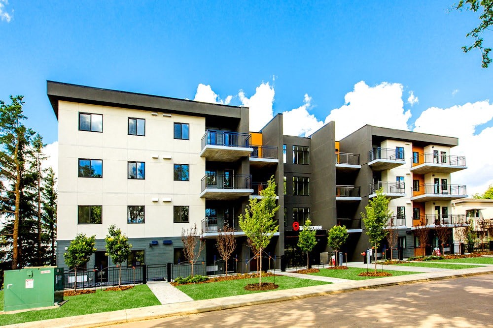 a row of modern apartment buildings with grass and trees