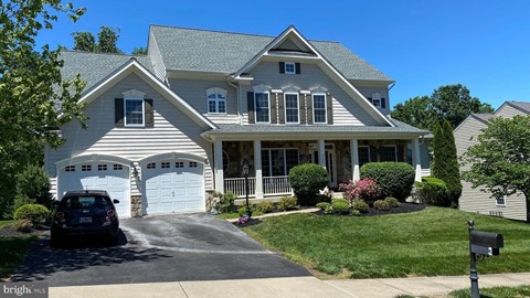 A house with a car parked in front of it.