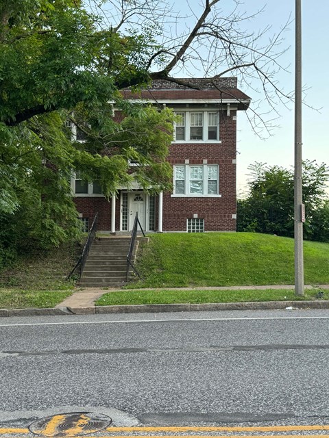 a red brick house with stairs in front of it