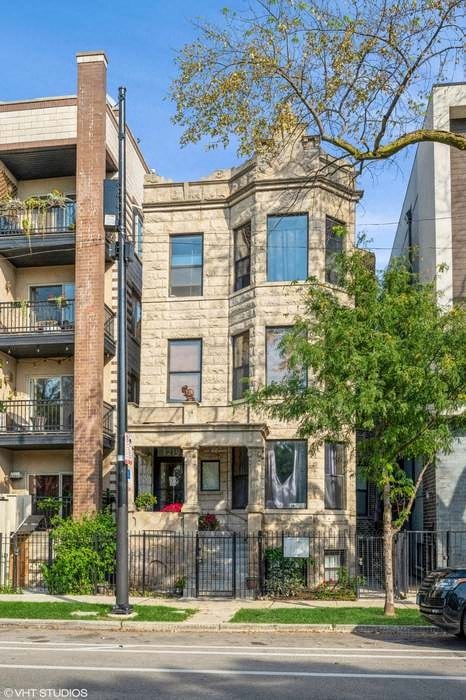 an apartment building with a street and a tree